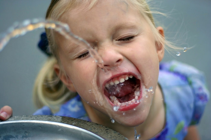 little girl drinking fountain water